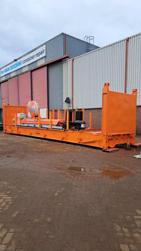 Oranje flat rack container met kabelhaspel en technische installatie bij Van Doorn Container Modifications