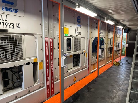 Binnenzijde van aangepaste zeecontainers met koelinstallaties en oranje vloer bij Van Doorn Container Modifications