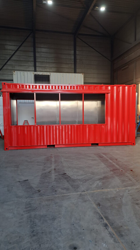 Rode zeecontainer met grote ramen omgebouwd tot verkoop- of presentatieruimte in werkplaats van Van Doorn Container Modifications
